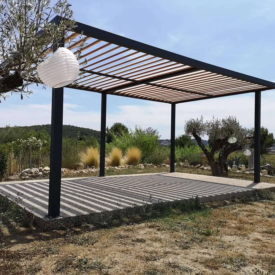Pergola autoportante sur mesure de 6 × 3 m, structure acier thermolaquée RAL 7016 et lames bois Douglas, sous une branche d'olivier, Caveirac (Gard)