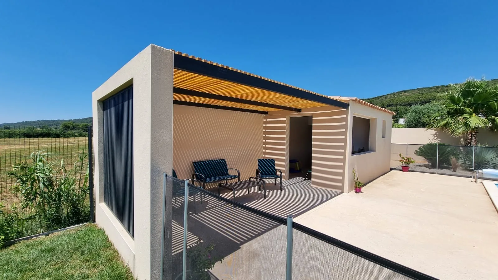 Pergola acier et claustra aluminium thermolaqués RAL 7016, claustra bois Douglas en couverture, pool house au bord de la piscine, Caveirac (Gard)