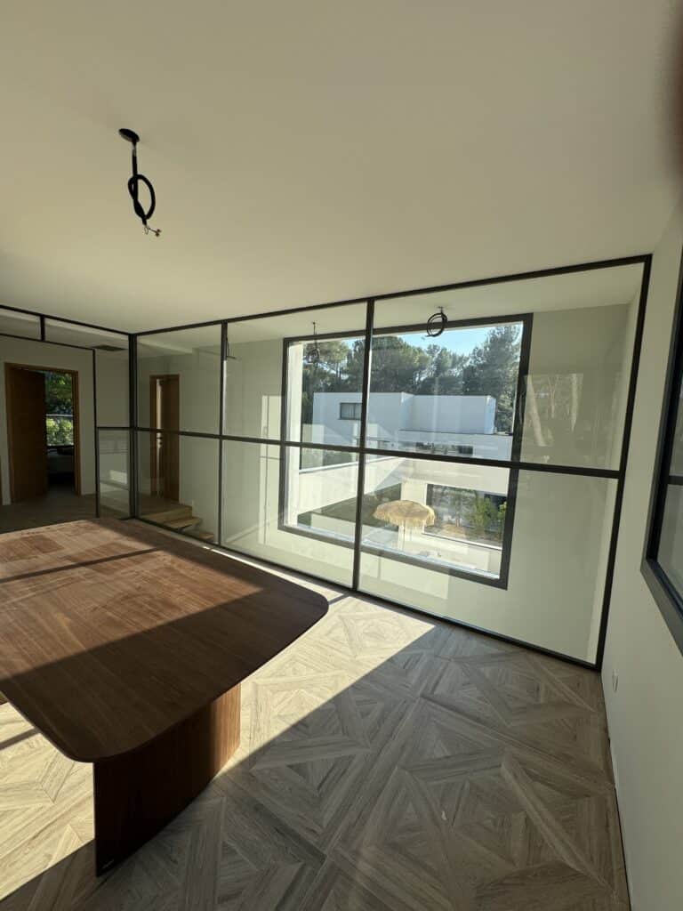 Verrière intérieure en acier sur mesure avec vue sur l'escalier dans une villa contemporaine à Montferrier-sur-Lez.